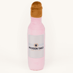 Plush Jackson Tails dog toy on a plain cream studio background