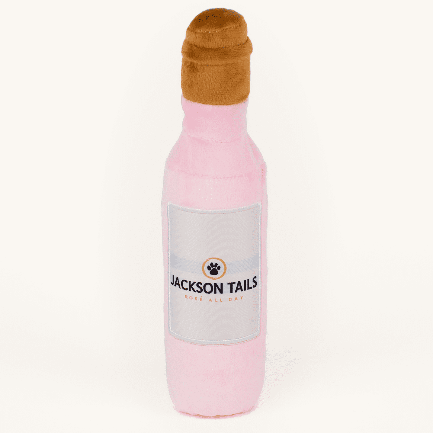 Plush Jackson Tails dog toy on a plain cream studio background