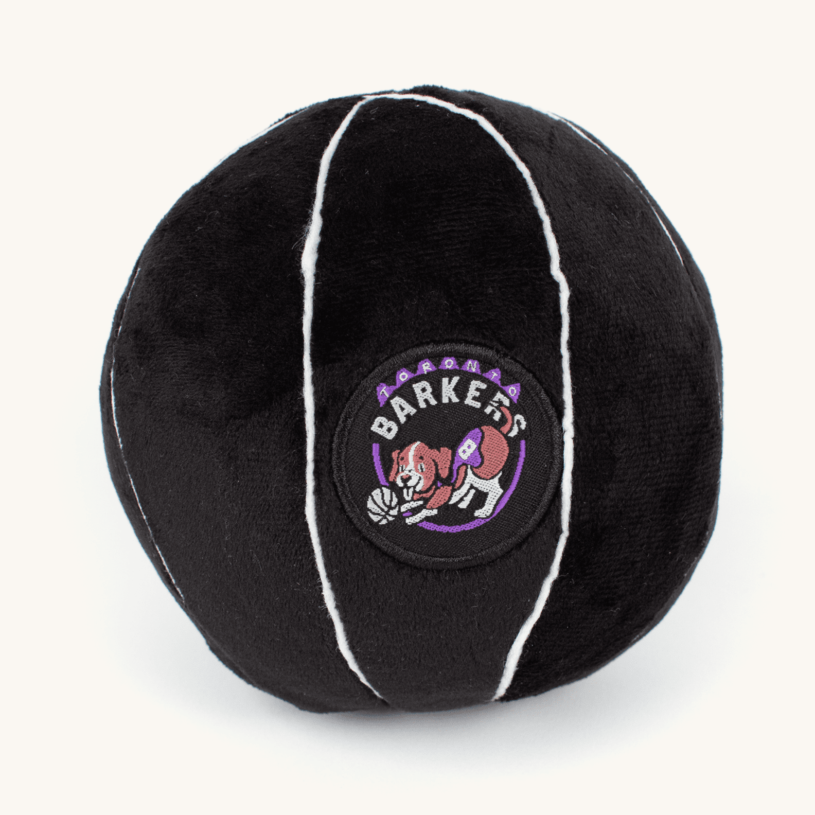 Plush basketball-shaped Toronto Barkers dog toy on a plain cream background