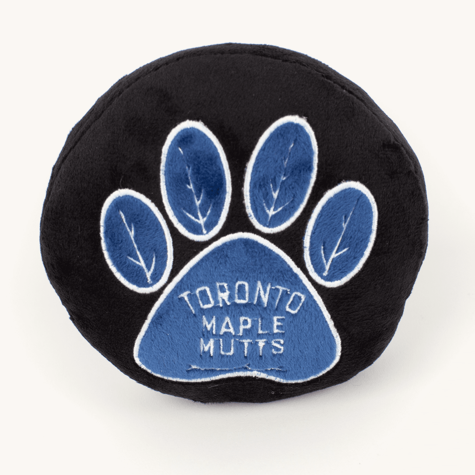 Plush Toronto Maple Mutts dog toy on a plain cream studio background